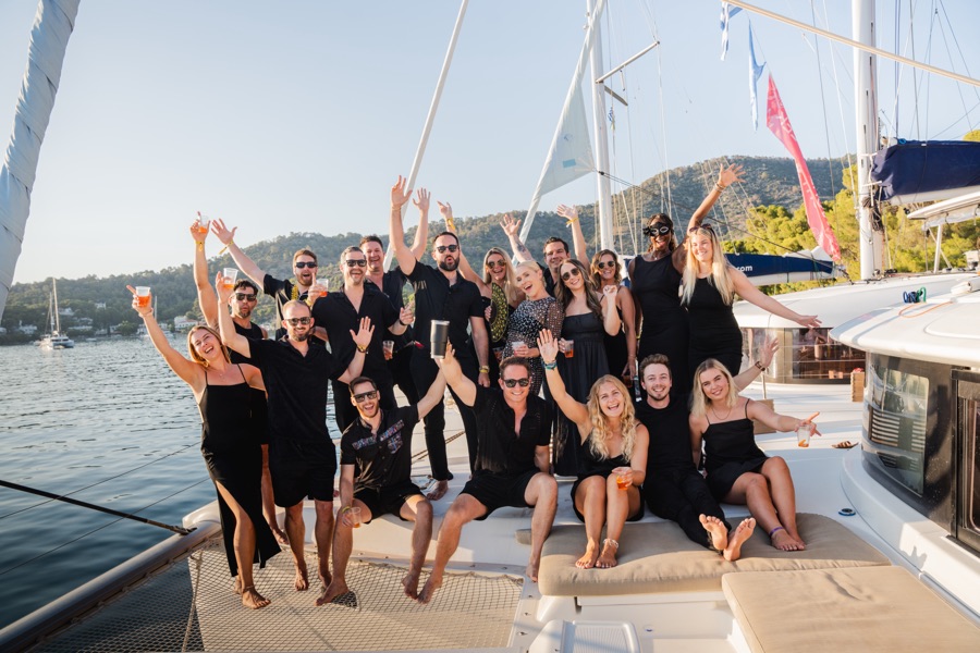 Raw golden-hour photograph of a Yacht Week crew on deck